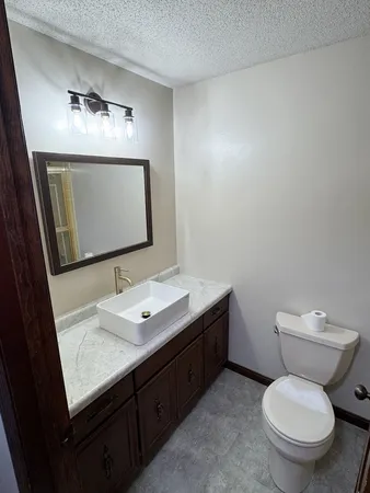 a bathroom with a toilet a sink and mirror