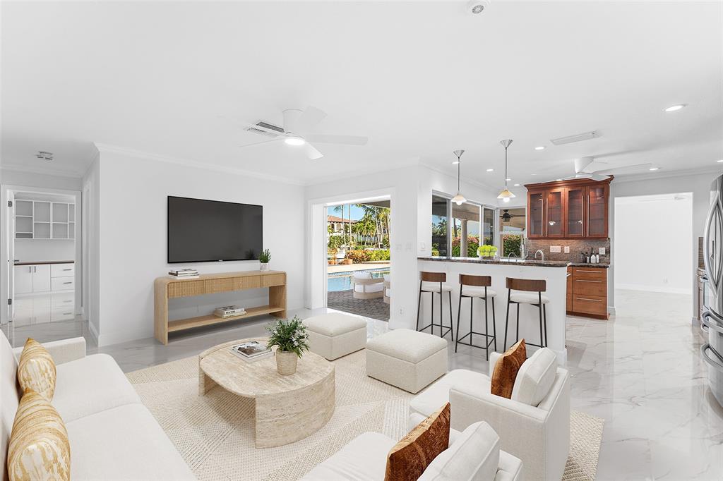 2443 Northeast 26th Street Lighthouse Point, FL 33064 - Photo 12 of 67 a living room with furniture kitchen view and a flat screen tv