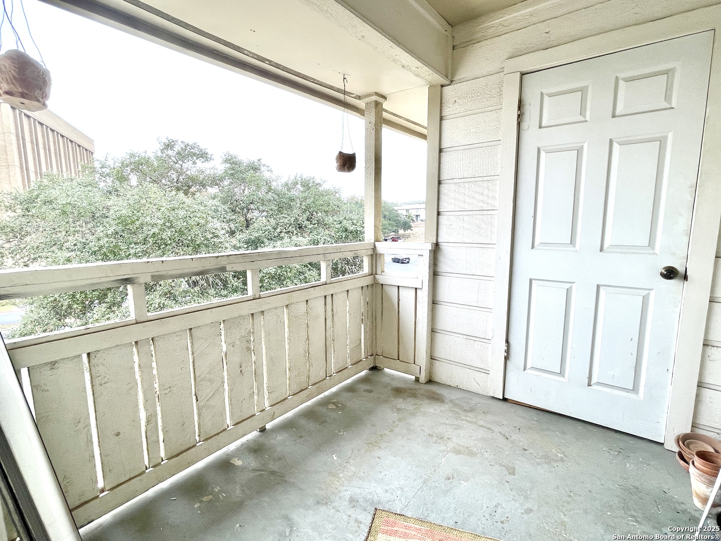 7738 Chambers Road, Unit 403 San Antonio, TX 78229 - Photo 8 of 37 a view of a balcony with wooden floor and white fence