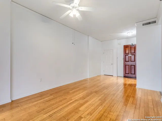 a view of an empty room with wooden floor