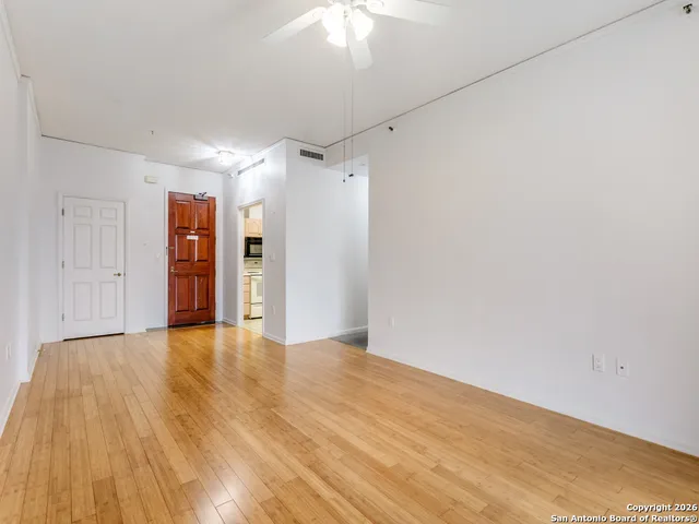 a view of empty room with wooden floor and window