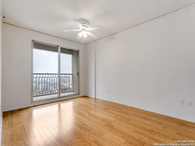 a view of an empty room with wooden floor