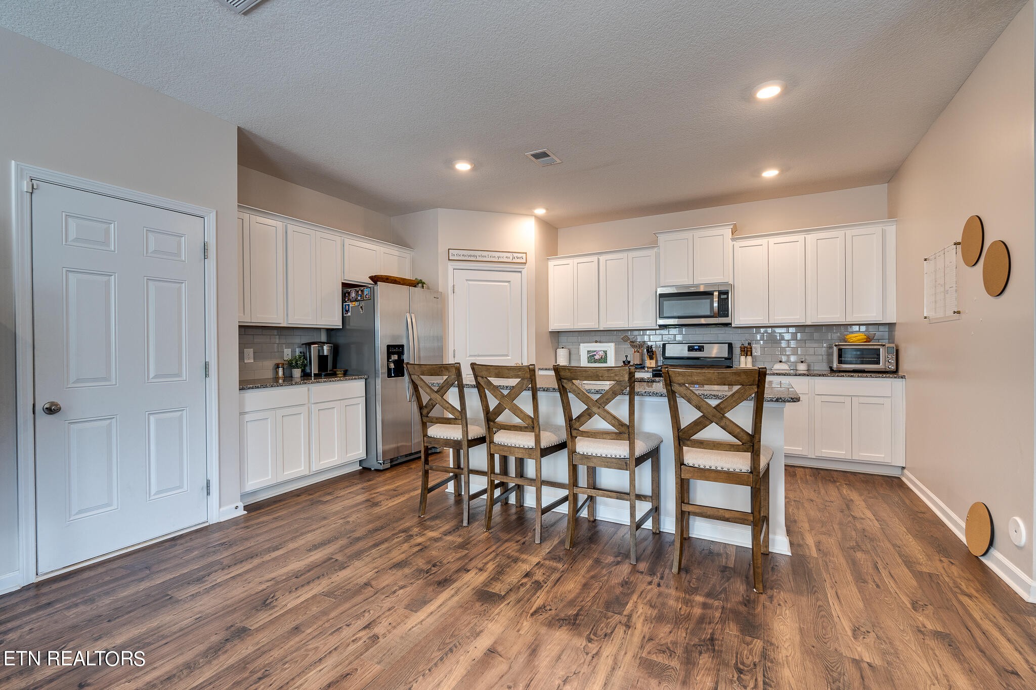 1117 Beacon Road Sevierville, TN 37876 - Photo 12 of 55 a kitchen with stainless steel appliances kitchen island granite countertop a refrigerator a stove a sink and white cabinets with wooden floor