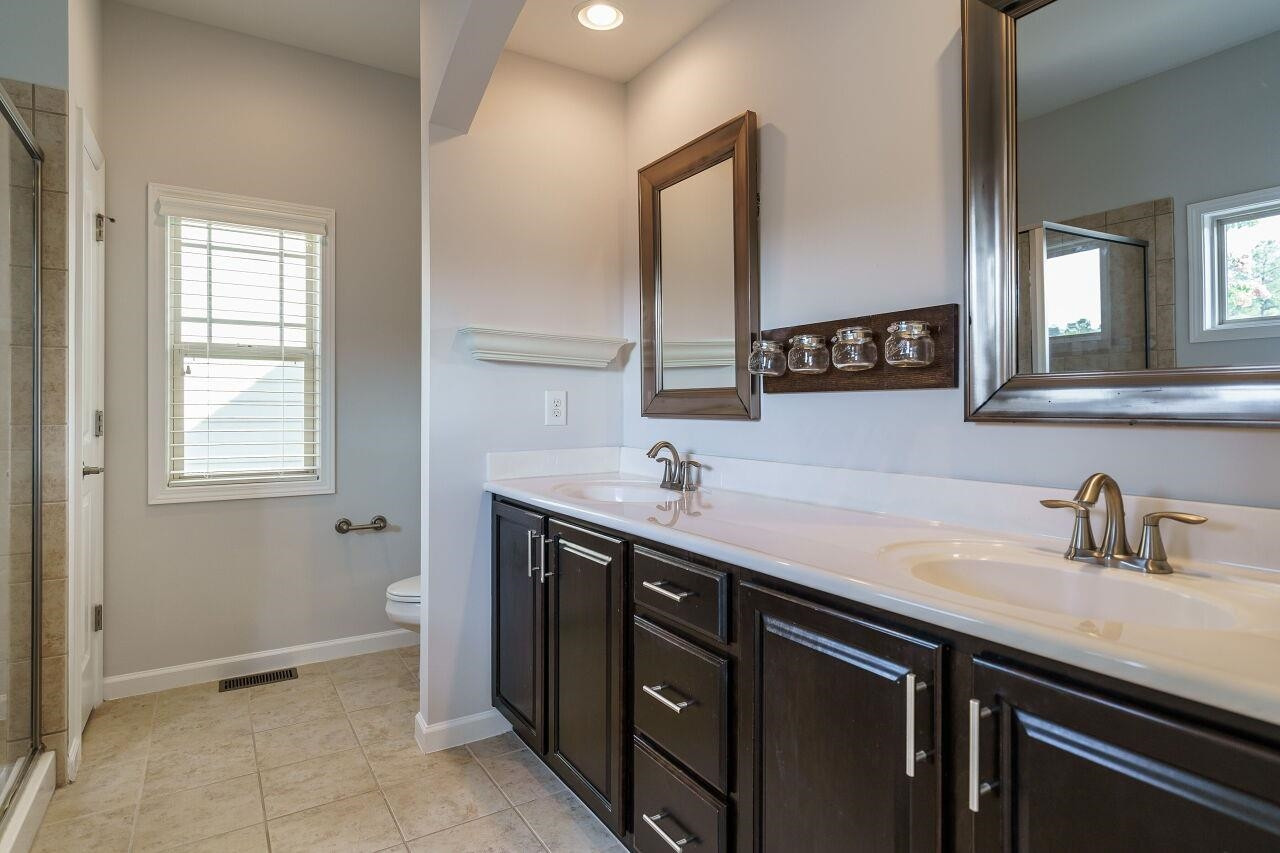 1340 Rodessa Run Raleigh, NC 27607 - Photo 18 of 29 Large owner's suite with tray ceiling, WIC with wooden shelving, two sinks, tile, garden tub and separate glass enclosed shower! Owner's Suite
