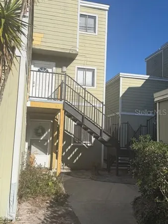 a view of a house with a small yard and wooden floor and fence