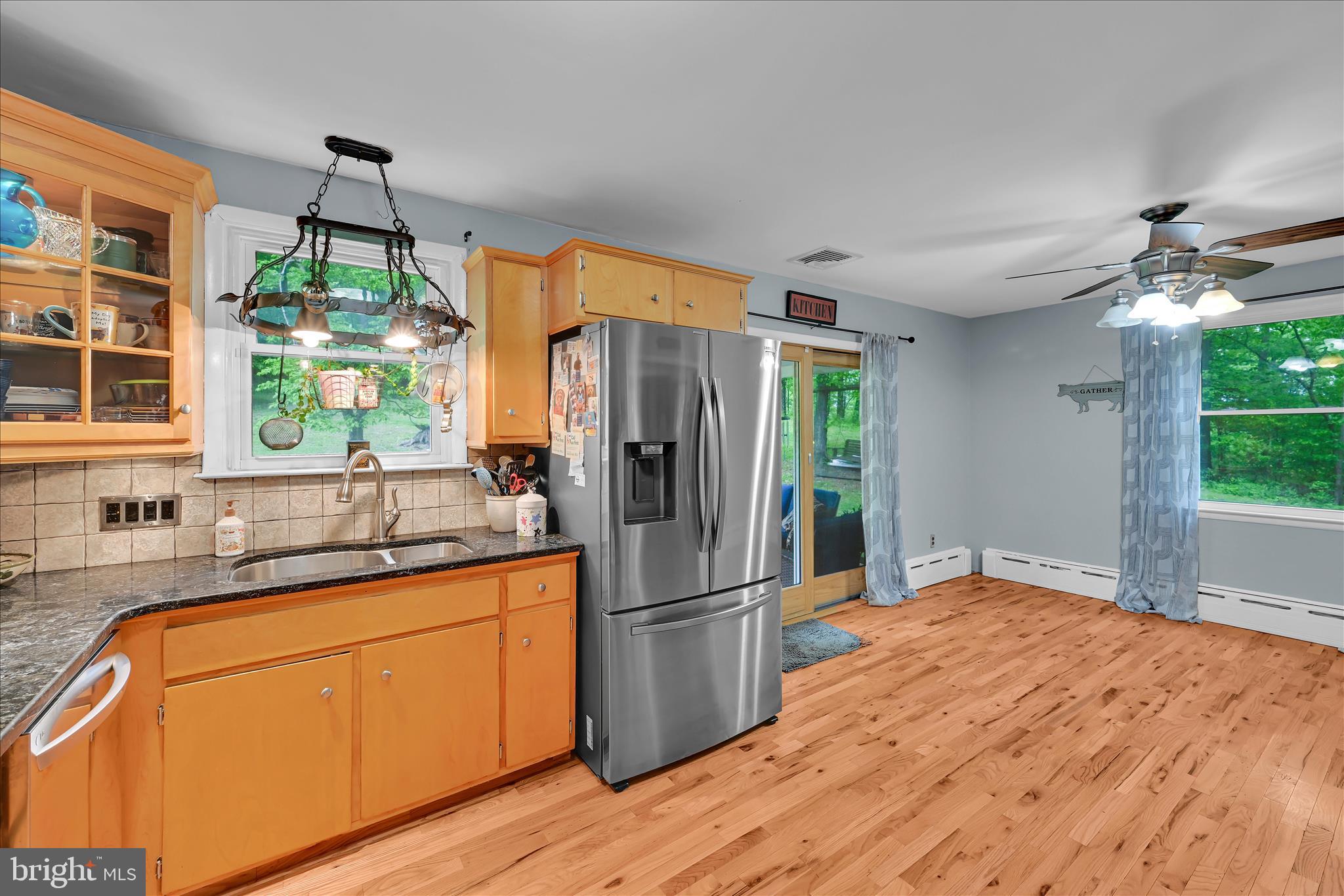 5220 Oley Turnpike Road Reading, PA 19606 - Photo 26 of 85 a kitchen with stainless steel appliances granite countertop a refrigerator a sink dishwasher a stove a dining table and chairs with wooden floor