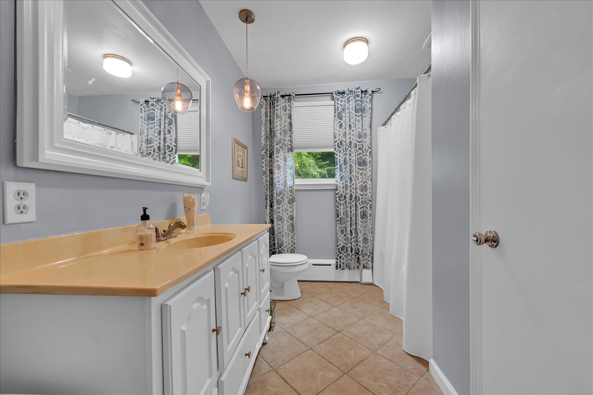 5220 Oley Turnpike Road Reading, PA 19606 - Photo 35 of 85 a bathroom with a sink a toilet a mirror and shower