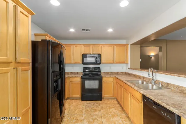 a kitchen with stainless steel appliances granite countertop a refrigerator and a sink