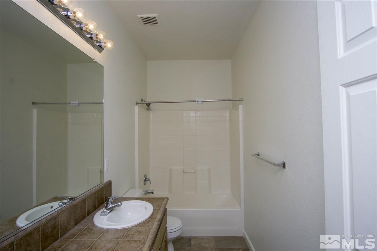 10598 Eagle Falls Way Reno, NV 89521 - Photo 12 of 17 a bathroom with a granite countertop sink a mirror and shower