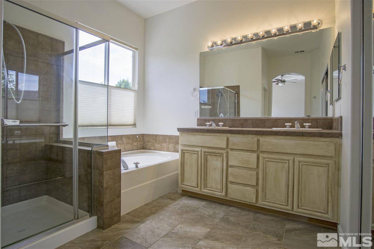 10598 Eagle Falls Way Reno, NV 89521 - Photo 9 of 17 a spacious bathroom with a granite countertop sink a mirror and a bathtub