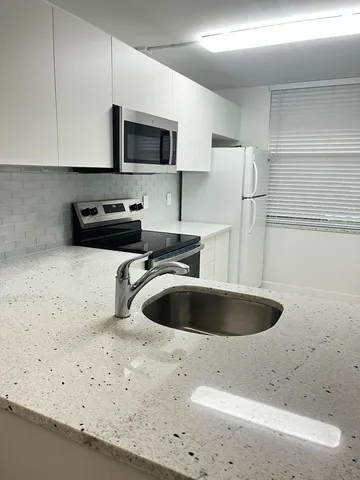 a kitchen with a sink stainless steel appliances and cabinets