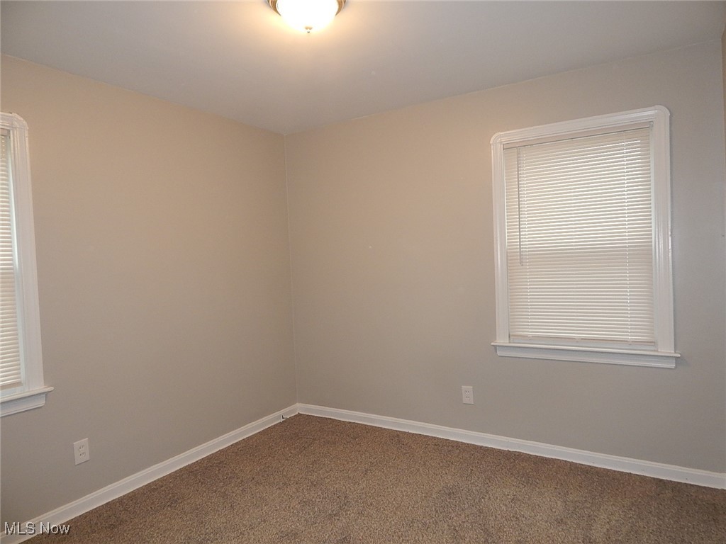Bedroom featuring baseboards and dark colored carpet