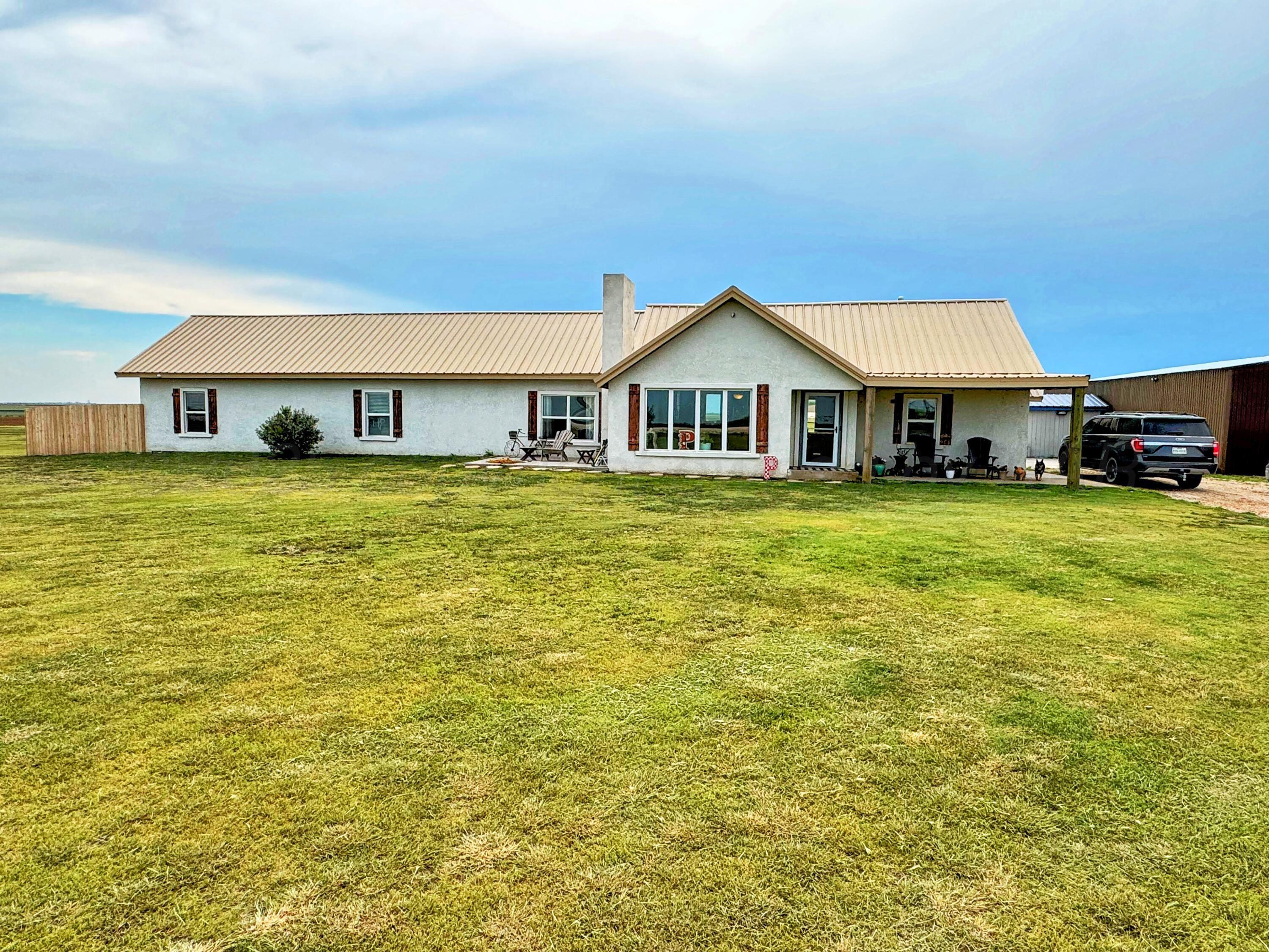 a view of a house with a big yard and large trees