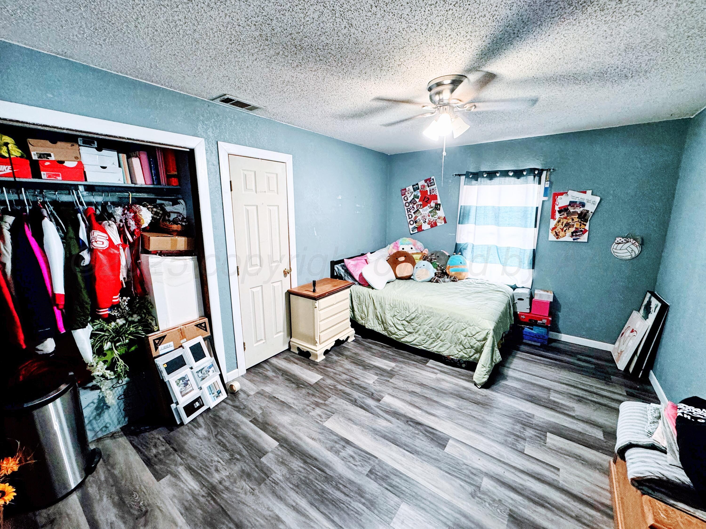 14155 County Road 7 Perryton, TX 79070 - Photo 12 of 25 a bedroom with furniture and a book shelf