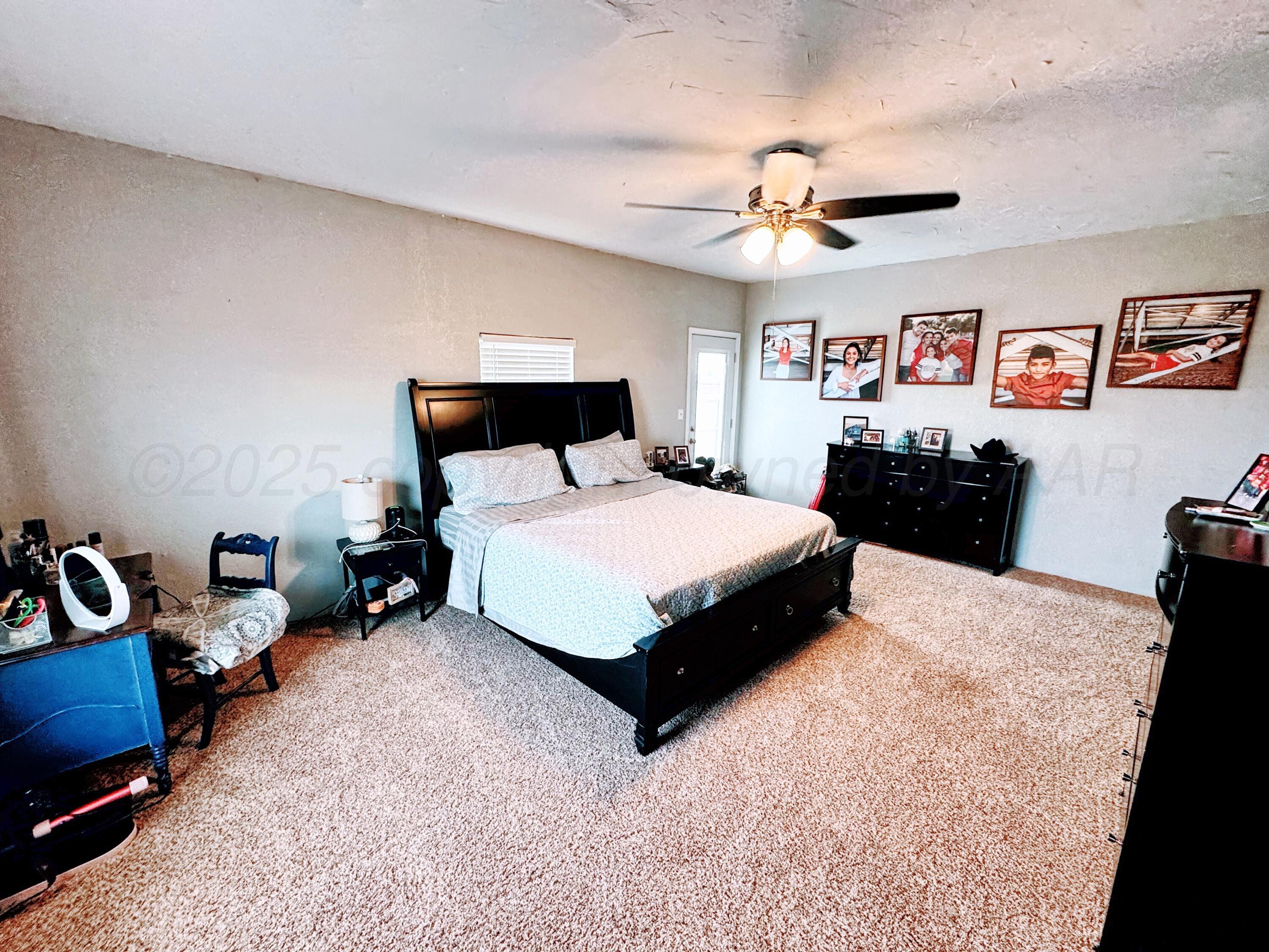 14155 County Road 7 Perryton, TX 79070 - Photo 14 of 25 a bedroom with a bed and a chandelier