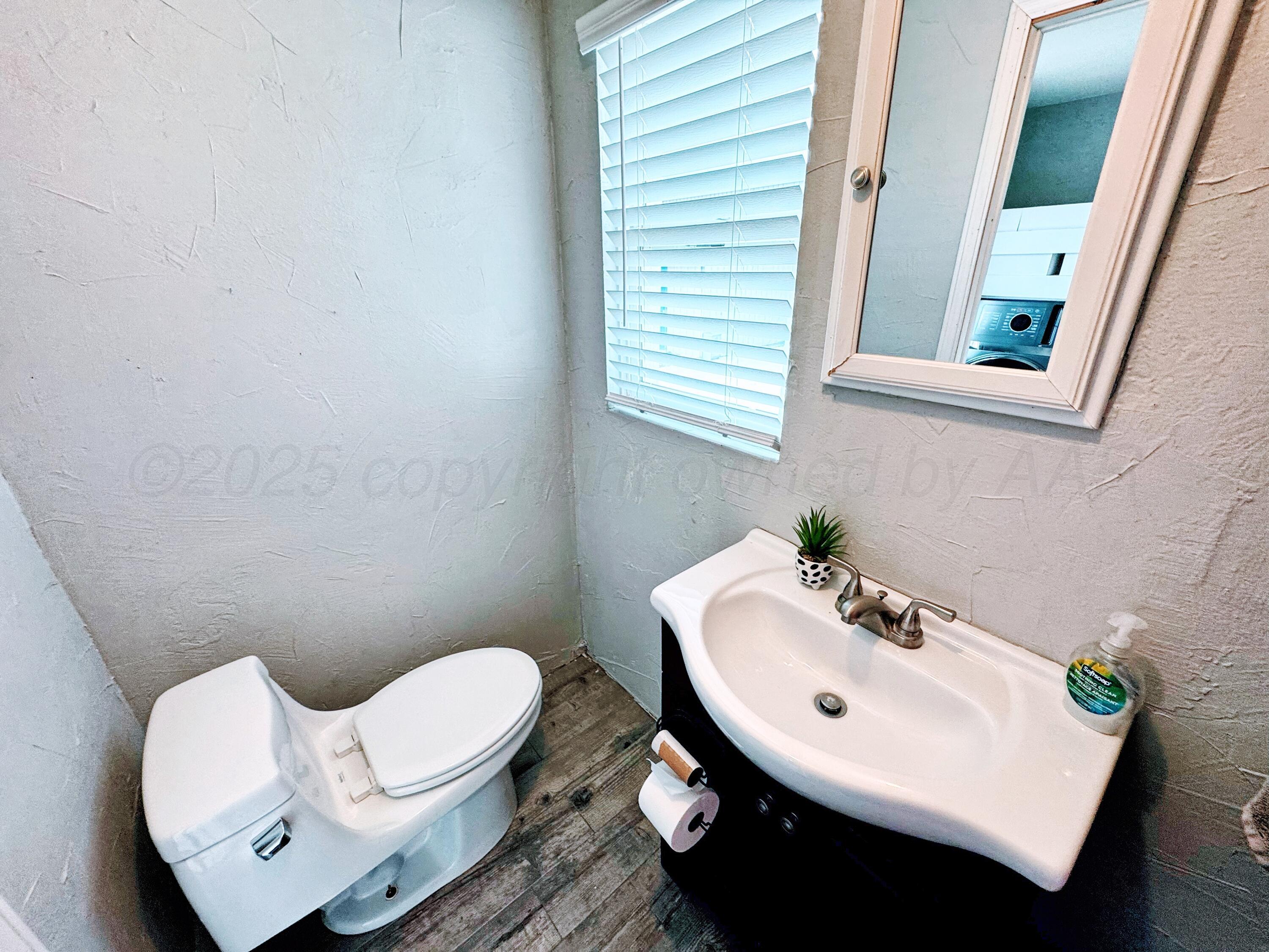 14155 County Road 7 Perryton, TX 79070 - Photo 17 of 25 a bathroom with a toilet sink and mirror