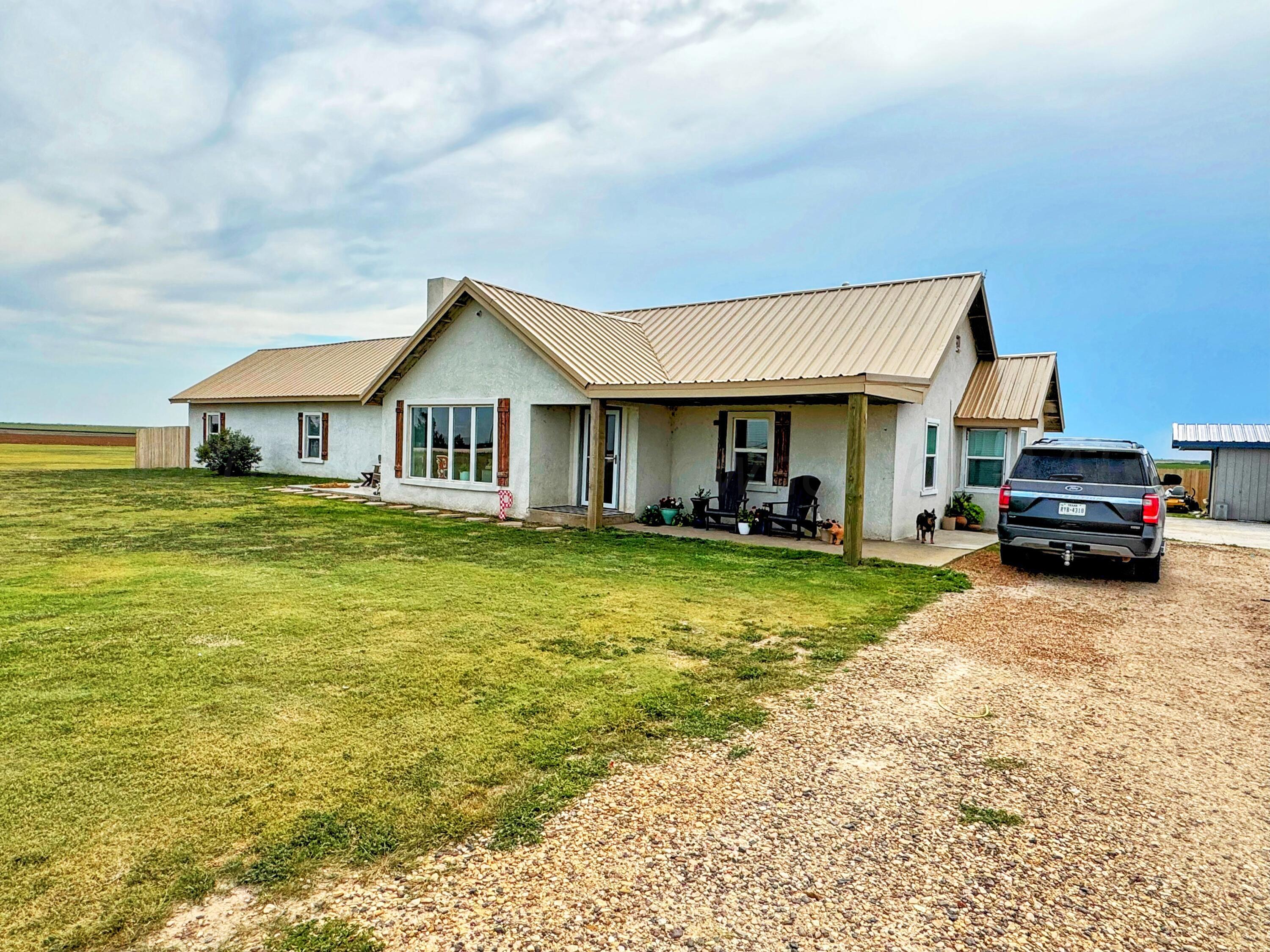 14155 County Road 7 Perryton, TX 79070 - Photo 2 of 25 a front view of a house with a garden and car parked