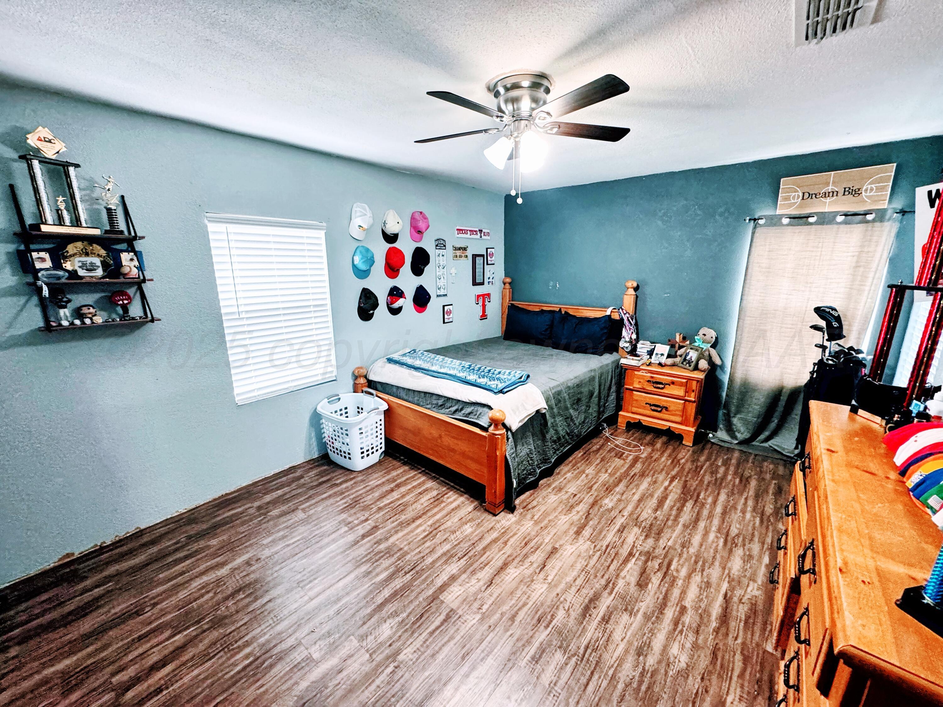 14155 County Road 7 Perryton, TX 79070 - Photo 8 of 25 a bedroom with furniture and wooden floor