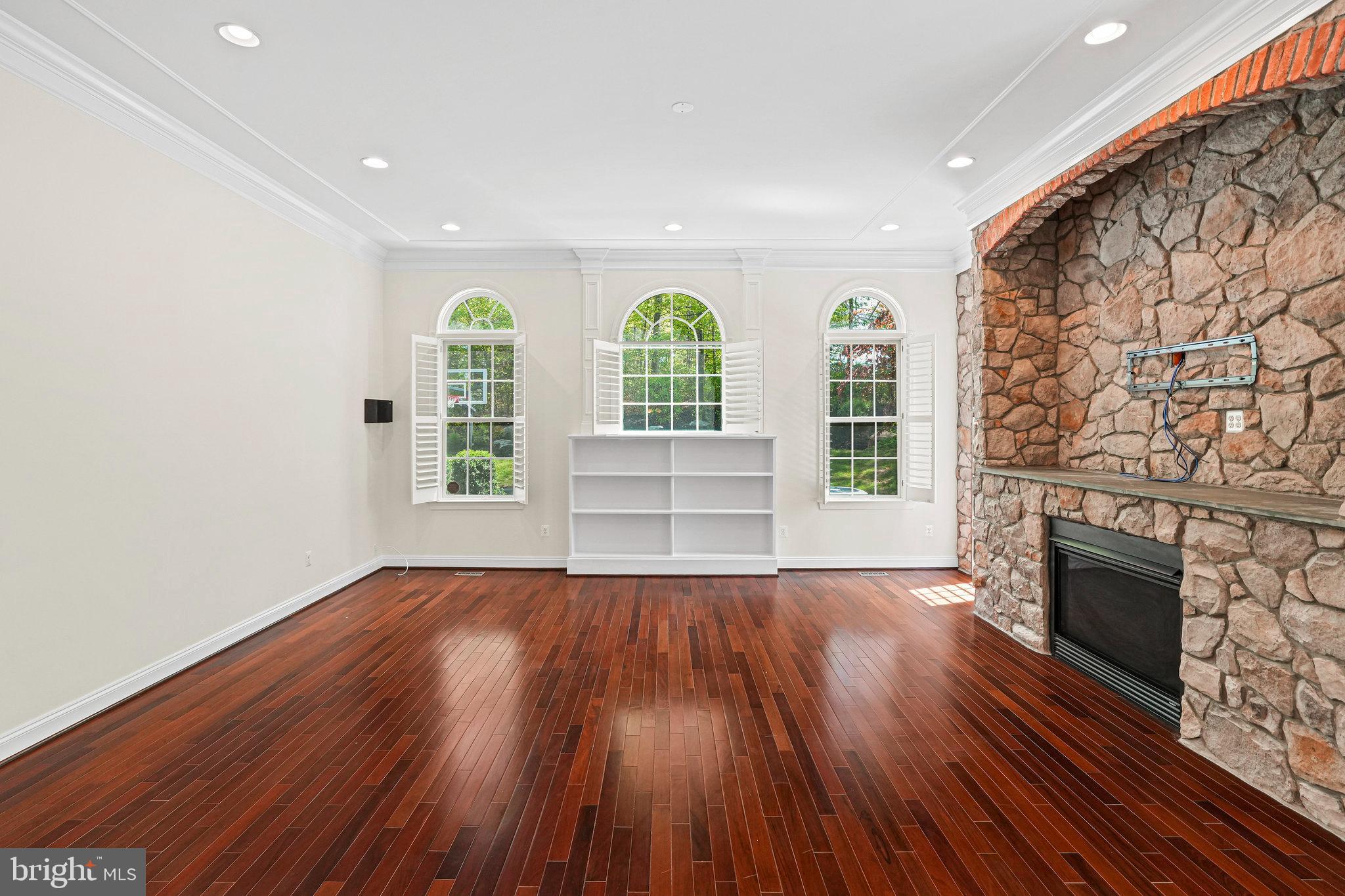 13551 Triadelphia Mill Road Clarksville, MD 21029 - Photo 10 of 74 an empty room with wooden floor fireplace and windows
