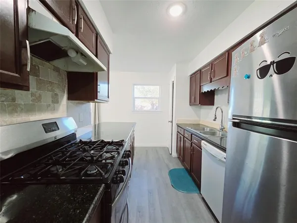a kitchen with stainless steel appliances granite countertop a stove a sink and a refrigerator