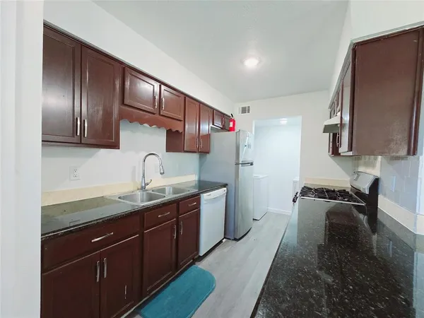 a kitchen with a sink a stove and cabinets
