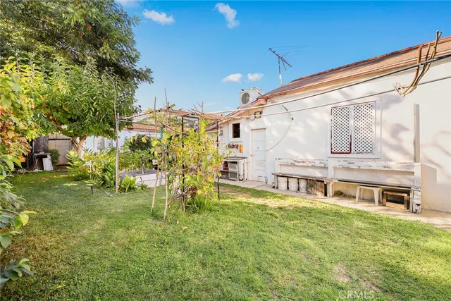 a view of a house with a big yard and large trees