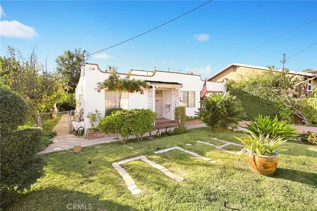 a view of a patio with table and chairs potted plants and large tree