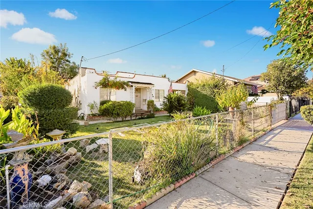 a view of a house with a yard and pathway