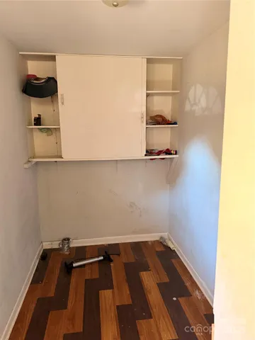 a view of small space with wooden floor and fan