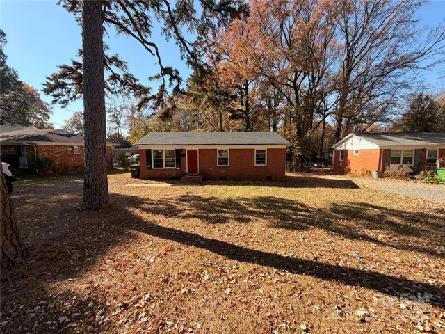 a view of house with outdoor space and covered with trees