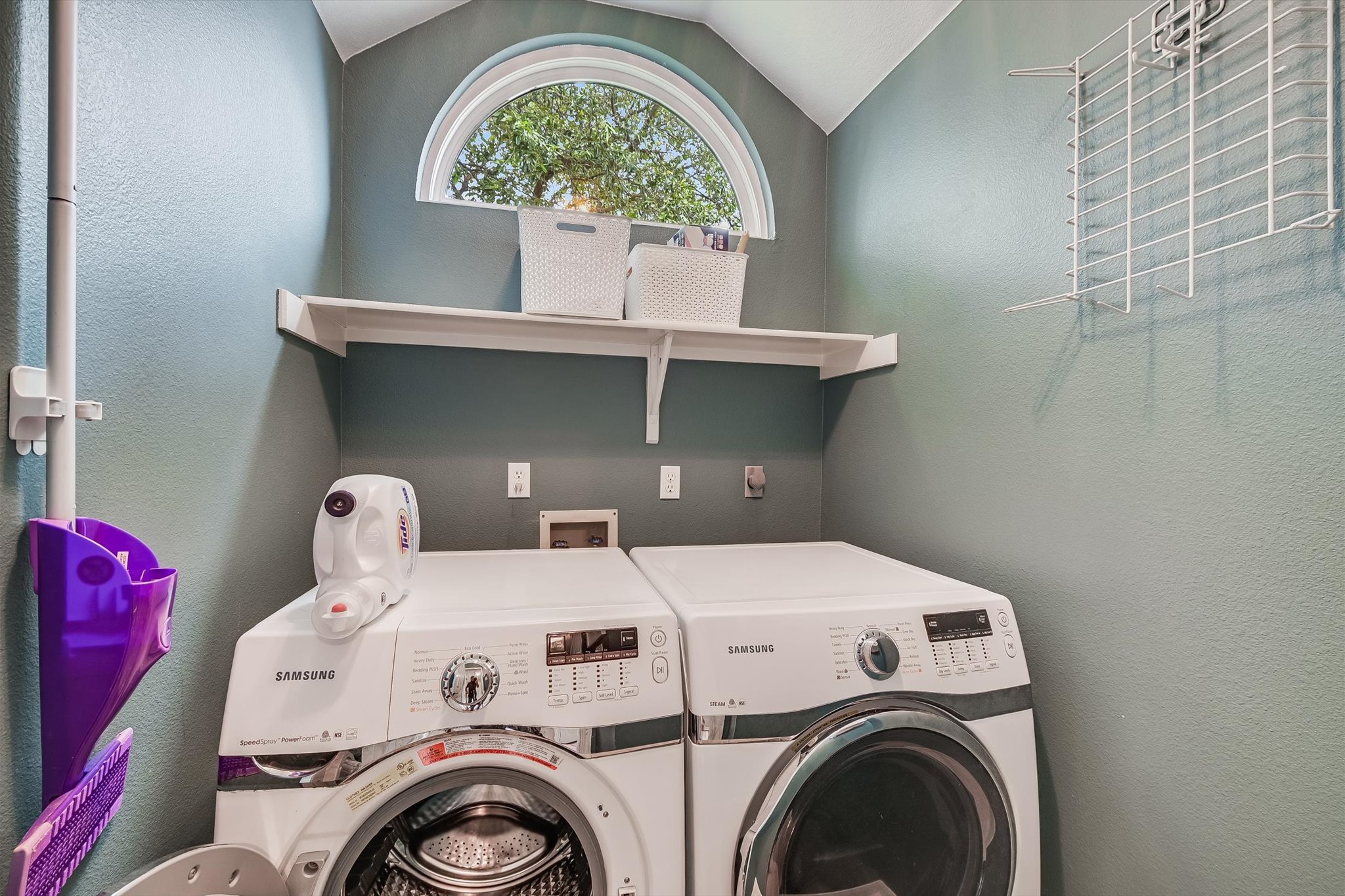 6456 Ruxton Lane Austin, TX 78749 - Photo 14 of 30 A well-organized laundry room features a convenient shelf and arched window, offering practical style.
