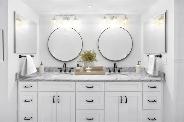 a bathroom with a granite countertop double vanity sinks and a mirror