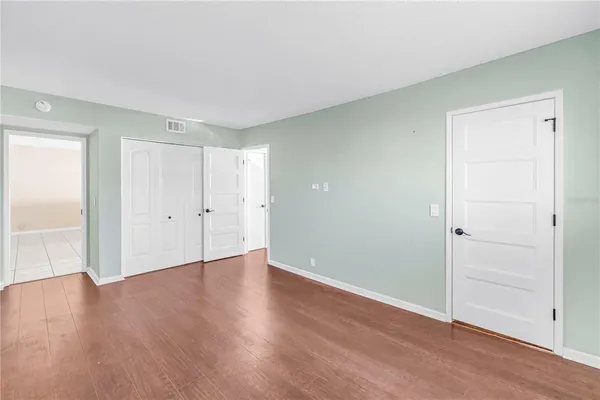 a view of an empty room with wooden floor