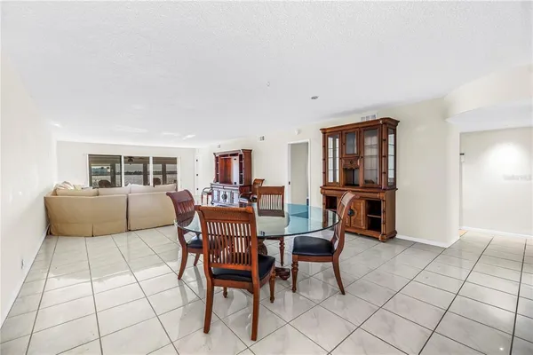 a living room with furniture a table and kitchen view