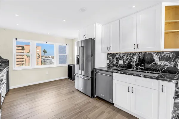 a kitchen with stainless steel appliances granite countertop a refrigerator and a sink