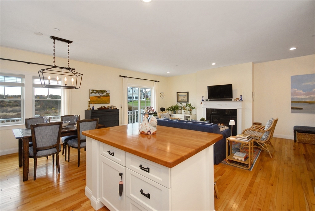 22 B Blacksmith Row, Unit B Groton, MA 01450 - Photo 14 of 24 a view of a dining room with furniture a chandelier and wooden floor