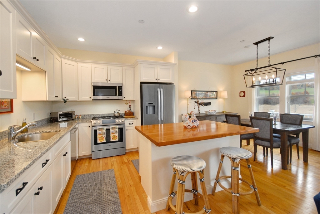 22 B Blacksmith Row, Unit B Groton, MA 01450 - Photo 15 of 24 a large kitchen with lots of counter space and stainless steel appliances