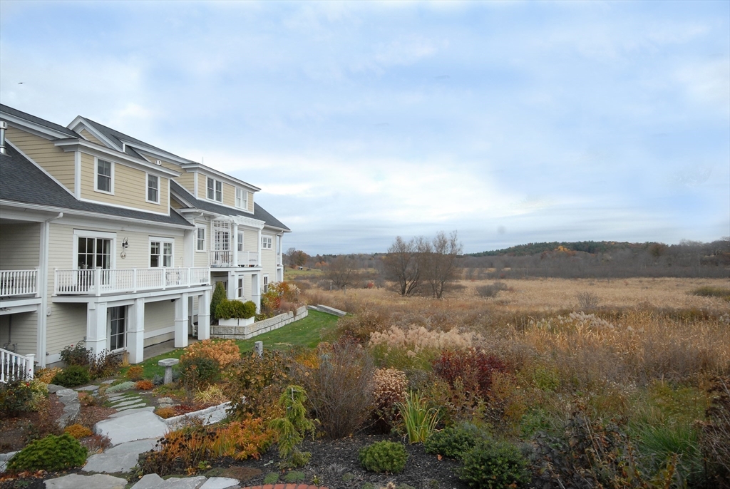 22 B Blacksmith Row, Unit B Groton, MA 01450 - Photo 2 of 24 a view of a lake with a mountain in the background