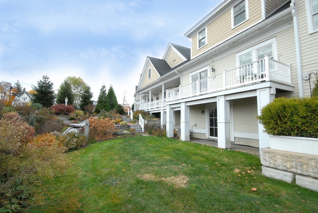 22 B Blacksmith Row, Unit B Groton, MA 01450 - Photo 3 of 24 a view of a house with a yard and sitting area