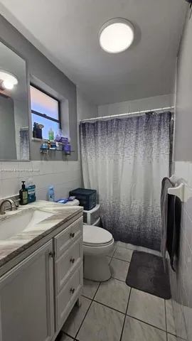 a bathroom with a granite countertop sink a toilet and a shower