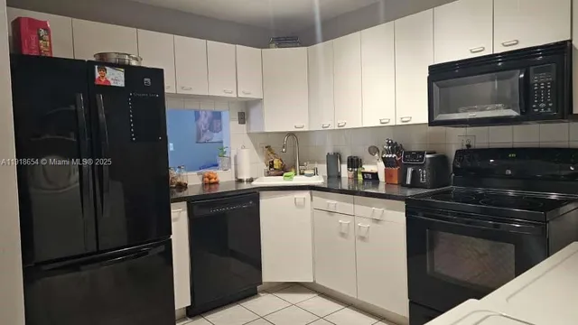a kitchen with a refrigerator sink and cabinets