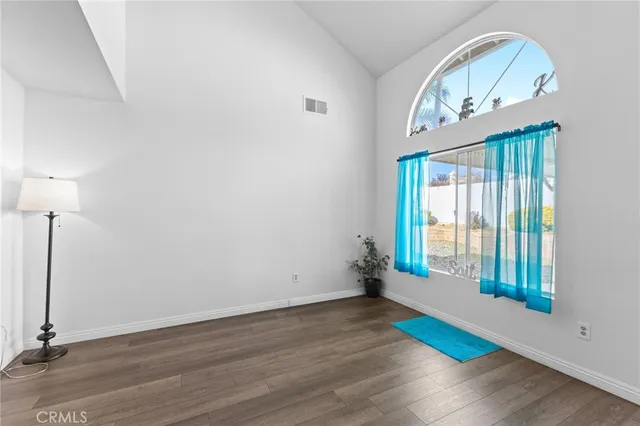 an empty room with wooden floor and a window