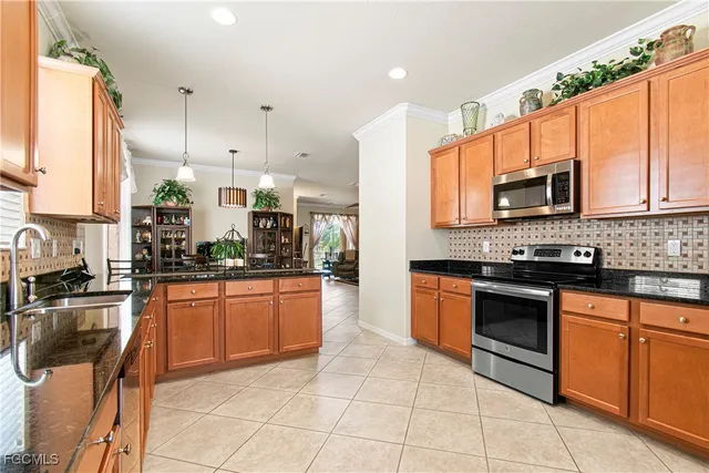 a kitchen with stainless steel appliances granite countertop a stove a sink and a microwave