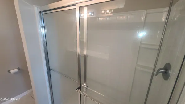 a bathroom with a glass shower door and a glass door