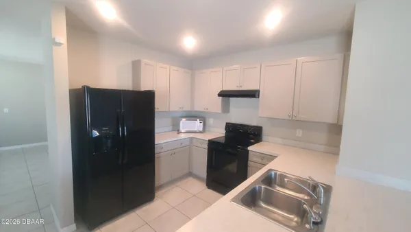 a kitchen with a refrigerator sink and cabinets