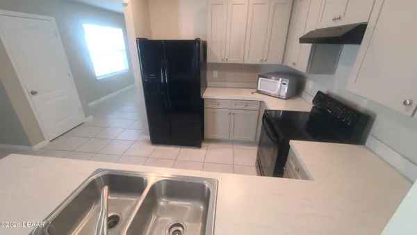 a kitchen with a refrigerator and a stove