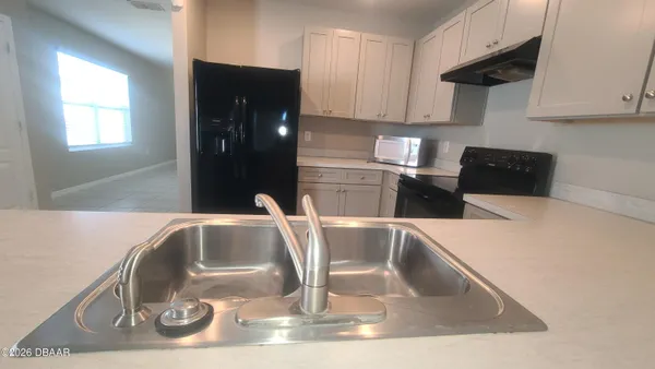 a kitchen with a sink a stove and cabinets