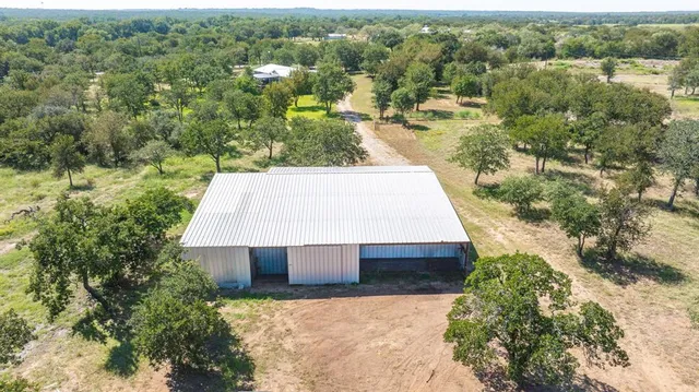 an aerial view of a house with a yard and lake view