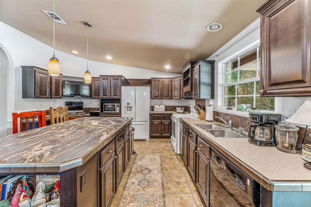 1071 Grimes Road Mineral Wells, TX 76067 - Photo 3 of 25 a kitchen with stainless steel appliances granite countertop a stove a sink a refrigerator and a microwave