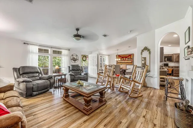 a living room with furniture a wooden floor and a large window